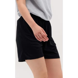 Black Core Shorts featuring an elastic waistband, shown worn with a grey top.
