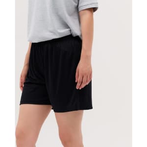 A pair of black shorts with an elastic waistband, modelled by a person wearing a grey shirt.