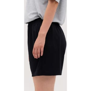 A pair of black shorts with an elastic waistband, displayed on the side with a neutral background.