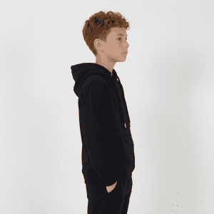 A black youth hoodie is displayed, featuring a hood and a kangaroo pocket. The model is a child with curly hair.