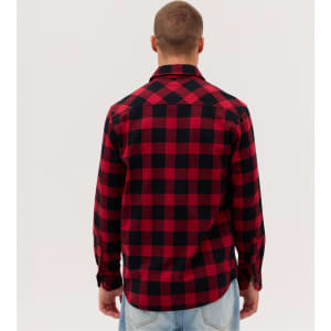 A man is wearing a red and black plaid long sleeve flannel shirt, viewed from the back. The shirt has a collar and buttons.