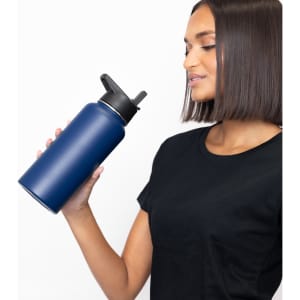 A drink bottle in navy blue, featuring a double wall design and three lids, held by a person.