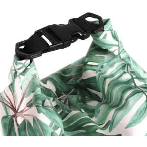 A waterproof dry bag featuring a tropical leaf design and a black buckle closure. It has a vibrant green and white colour scheme.