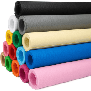 A stack of vibrant rolls of non-woven fabric in various colours, including blue, pink, green, and black, with a logo visible.