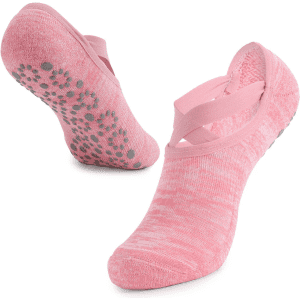 A pair of pink yoga socks featuring a crisscross design and textured grip on the soles.