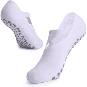 A pair of white yoga socks with a non-slip dotted sole and crisscross design. Features a logo on one sock.