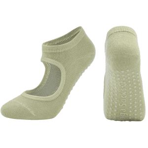 A pair of light green open-top yoga socks with a textured grip on the sole and a logo.