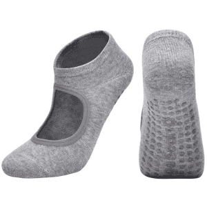 A pair of grey yoga socks with an open top and textured grip on the sole, featuring a logo.