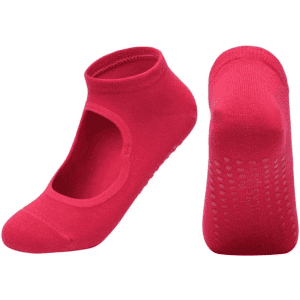 A pair of bright pink yoga socks with an open top and textured soles for grip. Features a logo on the side.