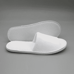 Open toe hotel slippers in white, featuring a soft fabric upper and textured sole. Includes a branding logo.