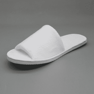 White open-toe hotel slippers with a soft fabric upper and flat rubber sole, featuring a simple design.