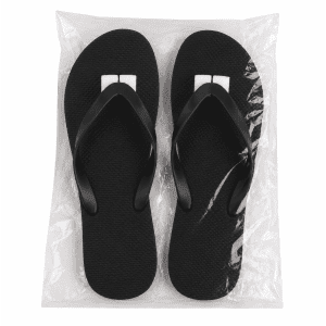 Black rubber thongs displayed on a clear bag, featuring a simple design and a logo on the straps.