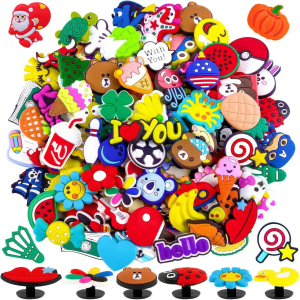 A collection of colourful PVC shoe charms in various shapes, including animals, food items, and phrases, with a mix of designs.