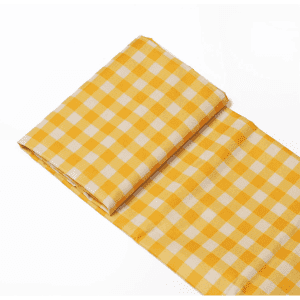A yellow and white checked picnic blanket folded neatly, featuring a slight sheen and a compact design.