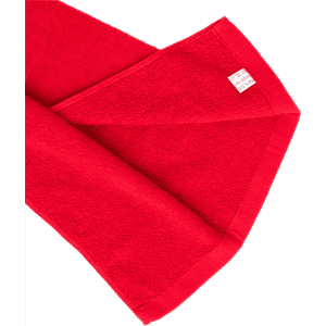 A red cotton golf towel with a label and a soft texture, folded to show its edges.