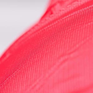 A close-up of a bright pink PVC material, showcasing its textured surface and vibrant colour.