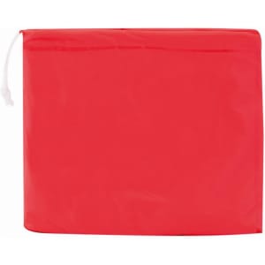 A red poncho is folded and packaged in a compact design, featuring a drawstring closure and a subtle logo.