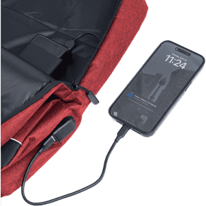 A red backpack with a charging port connected to a smartphone. It features a built-in power bank and a logo.