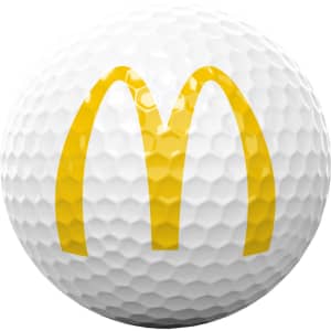 A white golf ball featuring a yellow logo on its surface. The ball has a textured, dimpled design.