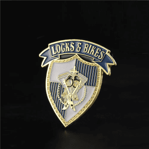 A custom enamel lapel pin featuring a gold and blue shield design with decorative elements and a logo.