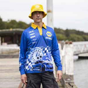 A man wearing a blue long sleeve polyester fishing polo with a graphic design and a yellow bucket hat.