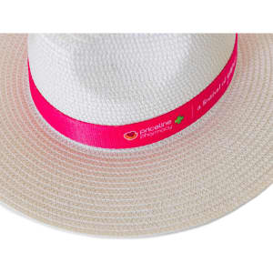 A white straw fedora hat with a bright pink band featuring a logo.