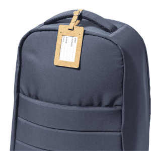 A navy backpack with a cork luggage tag attached, featuring a blank area for information.