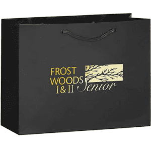 A black tote bag featuring a logo design in gold and a twisted handle.