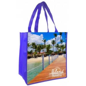 A purple tote bag featuring a full-colour beach scene with palm trees and a wooden walkway. It includes a logo.