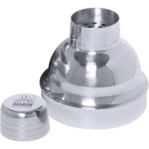 A silver cocktail shaker with a rounded shape and a lid, accompanied by a small, branded base.