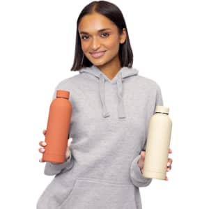 A drink bottle in rust and cream colours with double-wall insulation, featuring a logo and held by a smiling woman.