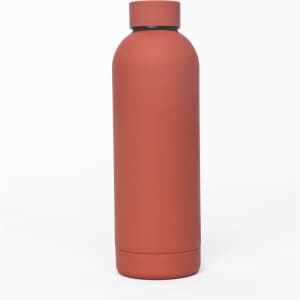 A drink bottle in a matte terracotta finish, featuring a double wall design and a discreet logo.