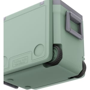 A green cooler box with wheels and a folding table, featuring a grey handle. Includes branding on the side.
