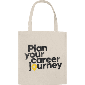 A natural-coloured tote bag with black text and a yellow marker icon. It features a logo.