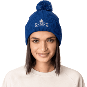 A blue beanie hat with a pom pom on top, featuring a logo on the front.