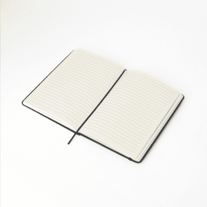 An open RPET notebook featuring lined pages and a black cover. The notebook has a ribbon bookmark.
