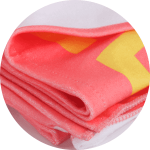 A folded sublimated beach towel in pink and yellow with a logo, showcasing a soft, vibrant design.