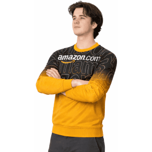 A yellow and black crew jumper featuring a logo and bold text design. The model stands with arms crossed.