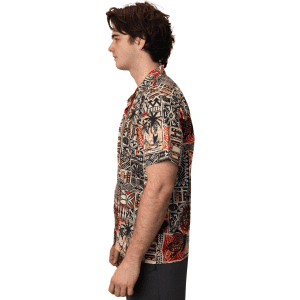 A button-up shirt featuring a vibrant, patterned design in shades of red, black, and beige. It has a logo on it.
