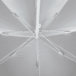 A white beach umbrella viewed from below, featuring a central pole and ribbing structure.