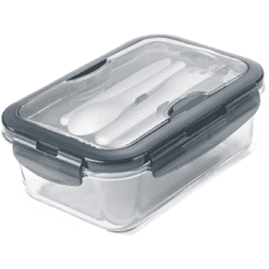 A clear lunch box with a grey lid, featuring a set of white utensils inside. The box has a secure sealing mechanism.
