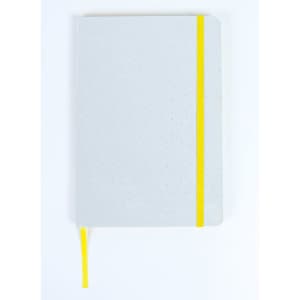 A grey notebook with a yellow elastic band and ribbon bookmark. It features a dotted interior design.