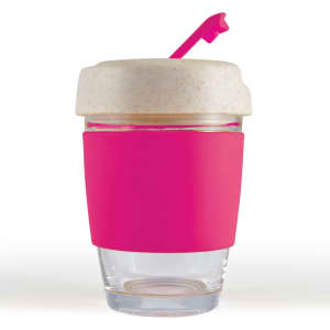 A reusable coffee cup with a clear body, pink silicone band, and a light-colored lid featuring a straw.
