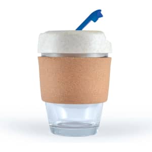 A reusable coffee cup in transparent glass with a cork band and a light-colored lid featuring a blue straw.