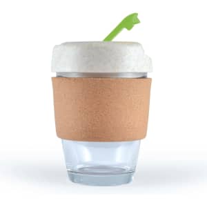 A reusable coffee cup with a cork band and a white lid featuring a green straw. The cup is made of transparent glass.
