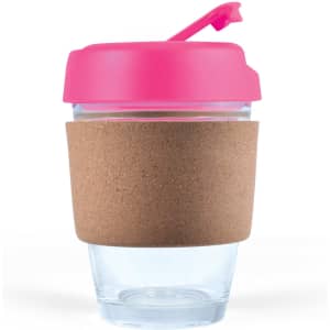 A reusable coffee cup with a transparent body, pink lid, and a cork band around the middle.