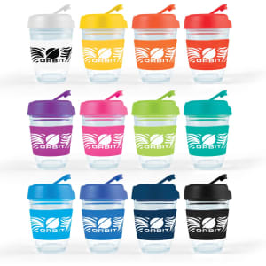 A set of reusable coffee cups in various colors with flip lids and branding. Each cup features a transparent body and a colored lid.