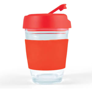A reusable coffee cup with a clear body and a bright red flip lid, featuring a matching silicone sleeve for grip.