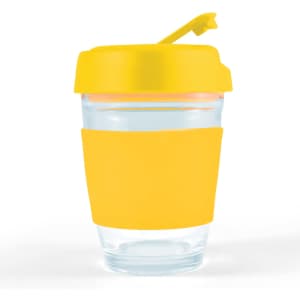 A reusable coffee cup with a clear glass body, yellow silicone sleeve, and yellow flip lid. It features a logo.