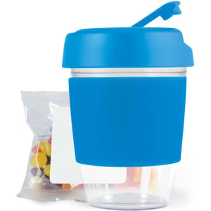 A reusable coffee cup in blue with a clear bottom and silicone sleeve, accompanied by a pack of jelly beans.